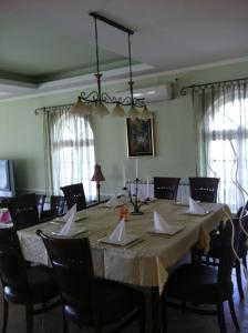 a dining room with a large table with chairs at SUNNY HOUSE APARTMENTS WITH an OUTDOOR POOL AND FREE PARKING in Skopje