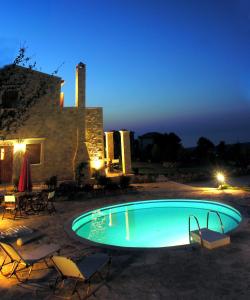 a swimming pool in front of a house at night at Cretan Exclusive Villas in Agia Triada