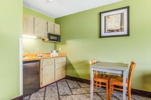 a small kitchen with a table and a sink at GuestHouse Inn & Suites Poulsbo in Poulsbo