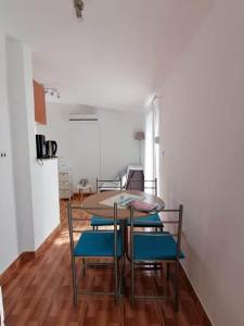 a dining room with a table and blue chairs at Apartment Krmpotić in Vir +28 photos