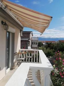a porch with chairs and awning on a house at Apartment Krmpotić in Vir