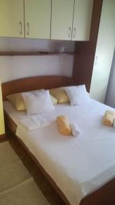 a large white bed with two pillows on it at Apartment Krmpotić in Vir