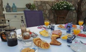 a table with breakfast foods and drinks on it at Anchor Apartments in Stari Grad