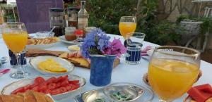 uma mesa com pratos de comida e copos de sumo de laranja em Anchor Apartments em Stari Grad