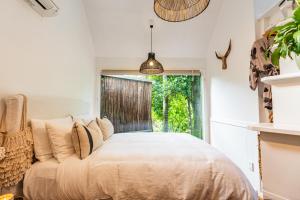 Palm Beach的住宿－Boho Hill Waiheke Island，一间卧室设有一张大床和一个窗户。