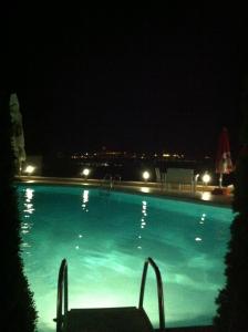 a swimming pool at night with a chair in it at Sunny House in Skopje