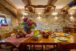 a dining room with a wooden table and a stone wall at b&b le nosare in Bosco Chiesanuova