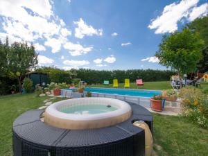 a hot tub in the grass next to a pool at Impronta di Gaia in Foiano della Chiana