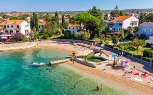 an aerial view of a beach with people in the water at Apartments White & Green in Malinska in Malinska