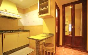 a kitchen with a counter and a stool in it at Apartamentos Bellavista in Artedo