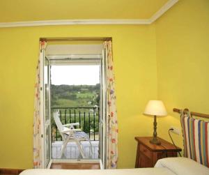 a bedroom with a door open to a balcony with a chair at Apartamentos Bellavista in Artedo