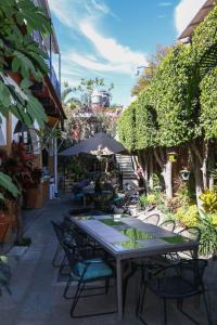 una mesa con sillas y una sombrilla en el patio en Las Mariposas Hotel & Studios en Oaxaca de Juárez