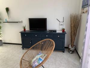 a black dresser with a television on top of it at Apartamentos Alberto in Morro del Jable