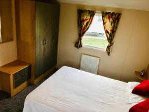 a bedroom with a white bed and a window at Luzern’s Heaven in Clacton-on-Sea