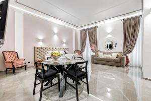 un soggiorno con tavolo, sedie e divano di UnoSeiTre - Luxury Apartment & Suite a Roma