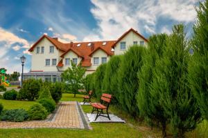 a house with a bench in a garden at Noclegi Cristal in Malbork