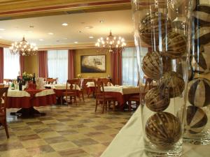 a dining room with tables and chairs and chandeliers at Hotel Pamplona Villava in Villava
