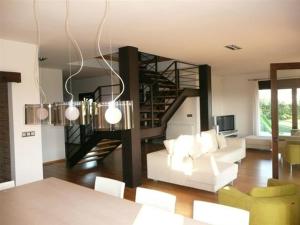 a living room with a white couch and a staircase at La Casa de Orviz in Siero