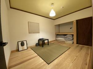 sala de estar con mesa y cama en mooi guesthouse 日新町, en Aizuwakamatsu