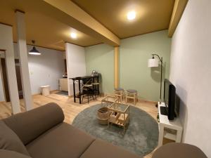 a living room with a couch and a table at mooi guesthouse 日新町 in Aizuwakamatsu