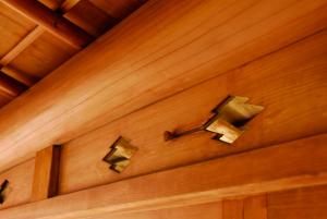 a wooden wall with two bells on it at Hakone Kowakien Mikawaya Ryokan in Hakone
