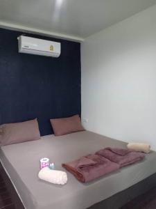 um quarto com uma cama com toalhas e um aquecedor em Patoo em Ko Chang