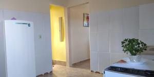 a kitchen with a white refrigerator and a plant on the counter at Casa Bela Paisagem in Mucugê