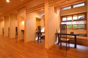 a dining room with a table and chairs and a window at Hakone Kowakien Mikawaya Ryokan in Hakone