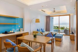 a kitchen and living room with a table and chairs at FLC Luxury Hotel Quy Nhon in Quy Nhon