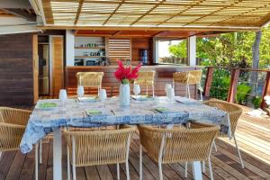 a dining table and chairs on a deck at Villa Oona in Maharepa