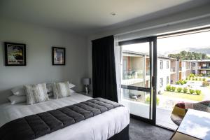 a bedroom with a bed and a large window at Central Park Apartments in Cromwell