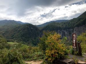 飯山市にあるゲストハウス 遊来の看板付きの山渓谷の景色