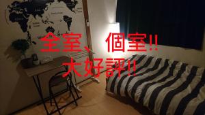 - une chambre avec un lit, une table et un bureau dans l'établissement UNLOCK SAKAI, à Sakai