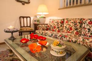 sala de estar con sofá y mesa con flores. en Albergo Tre Donzelle, en Siena