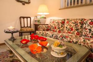a living room with a couch and a table with flowers on it at Albergo Tre Donzelle in Siena
