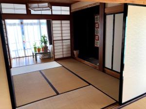 an entrance to a room with a door and a room withryu at Guest House Hostel yukuru in Iiyama