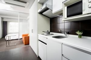 a kitchen with a sink and a microwave at Citadines Shinjuku Tokyo in Tokyo