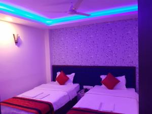 a room with two beds and a purple ceiling at Hotel delight deluxe in Pipra Dewās