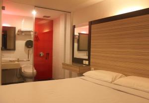 a bedroom with a bed and a bathroom with a toilet at Time Hotel in Seremban