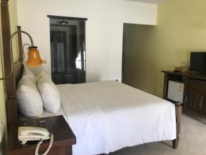 a hotel room with a bed and a phone at Ao Nang Colors Hotel - Aonang Beach in Ao Nang Beach