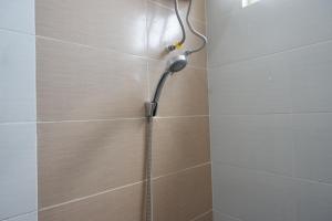 a shower with a shower head in a bathroom at RedDoorz Near PRPP Marina Semarang in Kalibanteng-lor +23 photos