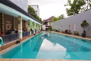 a swimming pool in front of a building at Meotel Purwokerto in Purwokerto
