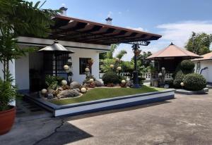 a garden in front of a house with a gazebo at SM Travelodge in Batangas City
