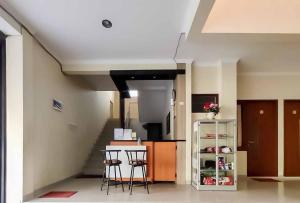a room with a kitchen with chairs and a counter at RedDoorz Syariah Plus near Cirebon Super Block Mall 2 in Cirebon