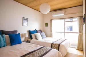 Duas camas num quarto com uma janela em Gentry Hakata em Fukuoka
