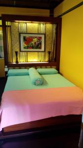 a bedroom with a large bed with colorful sheets at T Star Cottage Langkawi in Pantai Cenang