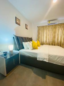 um quarto com uma cama com almofadas amarelas em OASIS PARK RESIDENCE em East Legon
