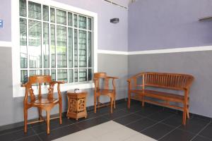 dwa krzesła i ławka w pokoju z oknem w obiekcie Homestay Hj Esmon 3 UTHM Parit Raja w mieście Parit Raja