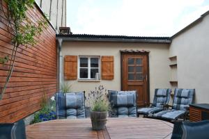 a patio with four chairs and a wooden table at Ferienhaus 7. Kaiser in Quedlinburg