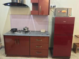 kuchnia z kuchenką i czerwoną lodówką w obiekcie One Bed Studio Apartment near Shaukat Khanum w mieście Lahaur